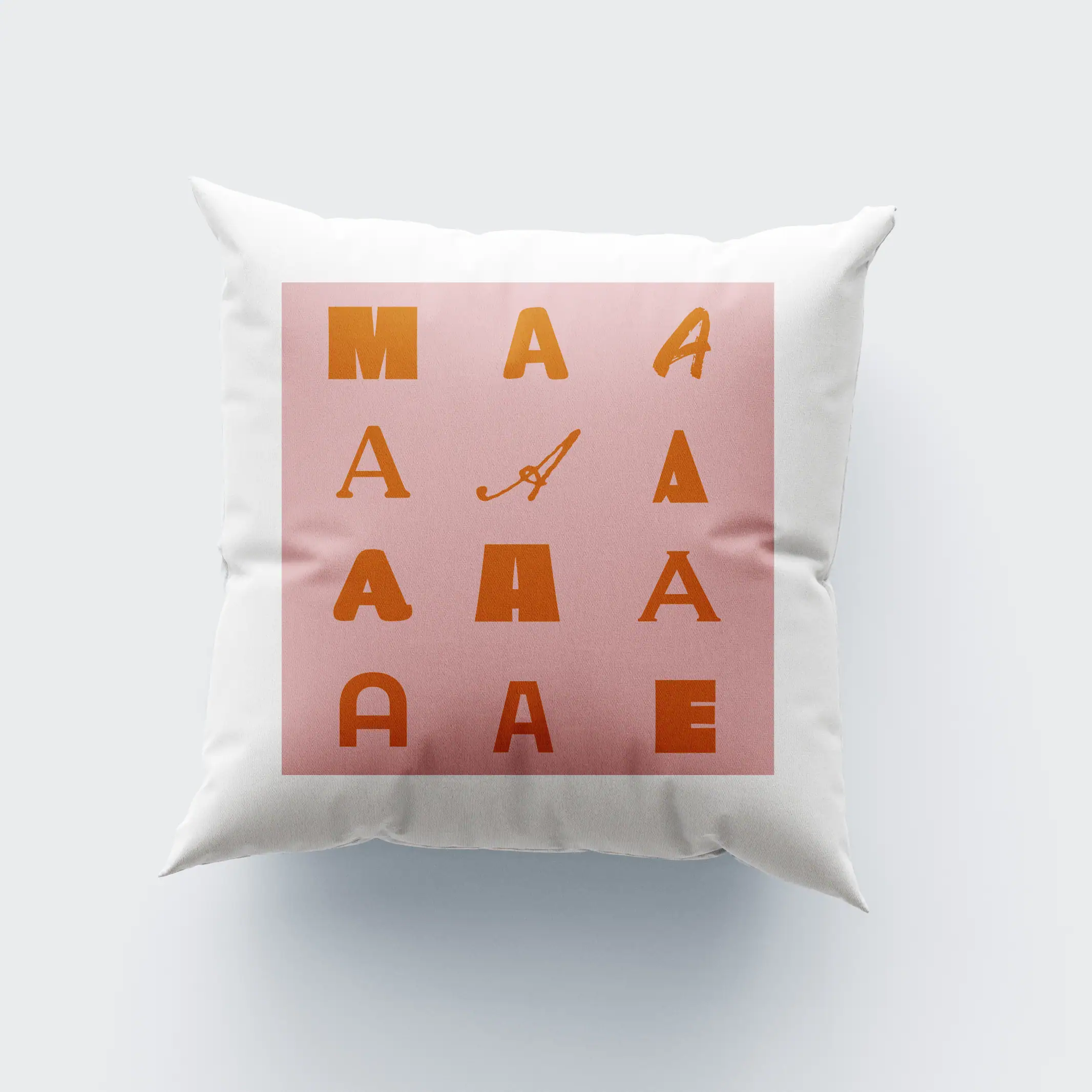 AlmofadaMãe Letras do alfabeto "A" decorativas em relevo na almofada branca com fundo rosa.