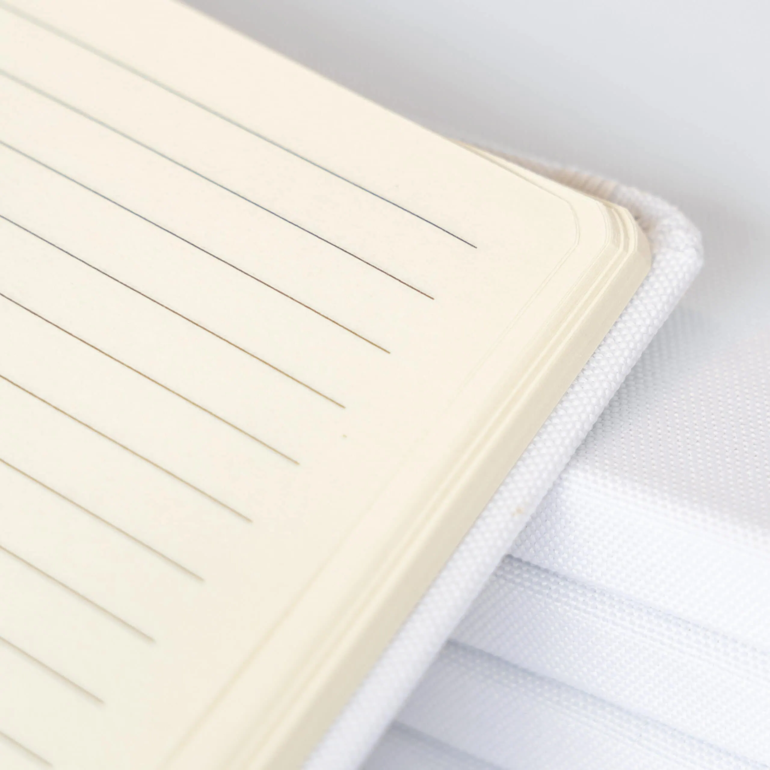 Notas de leitura de caderno com linhas elegantes e tecido branco, ideal para organização e estudo.