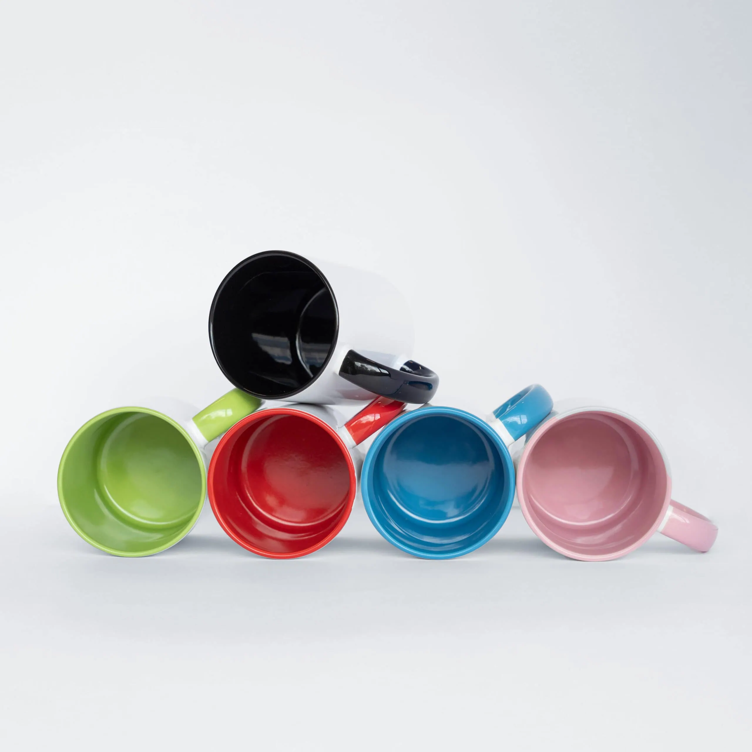 Cores coloridas de canecas de cerâmica empilhadas, ideal para presentes e decoração de cozinha.