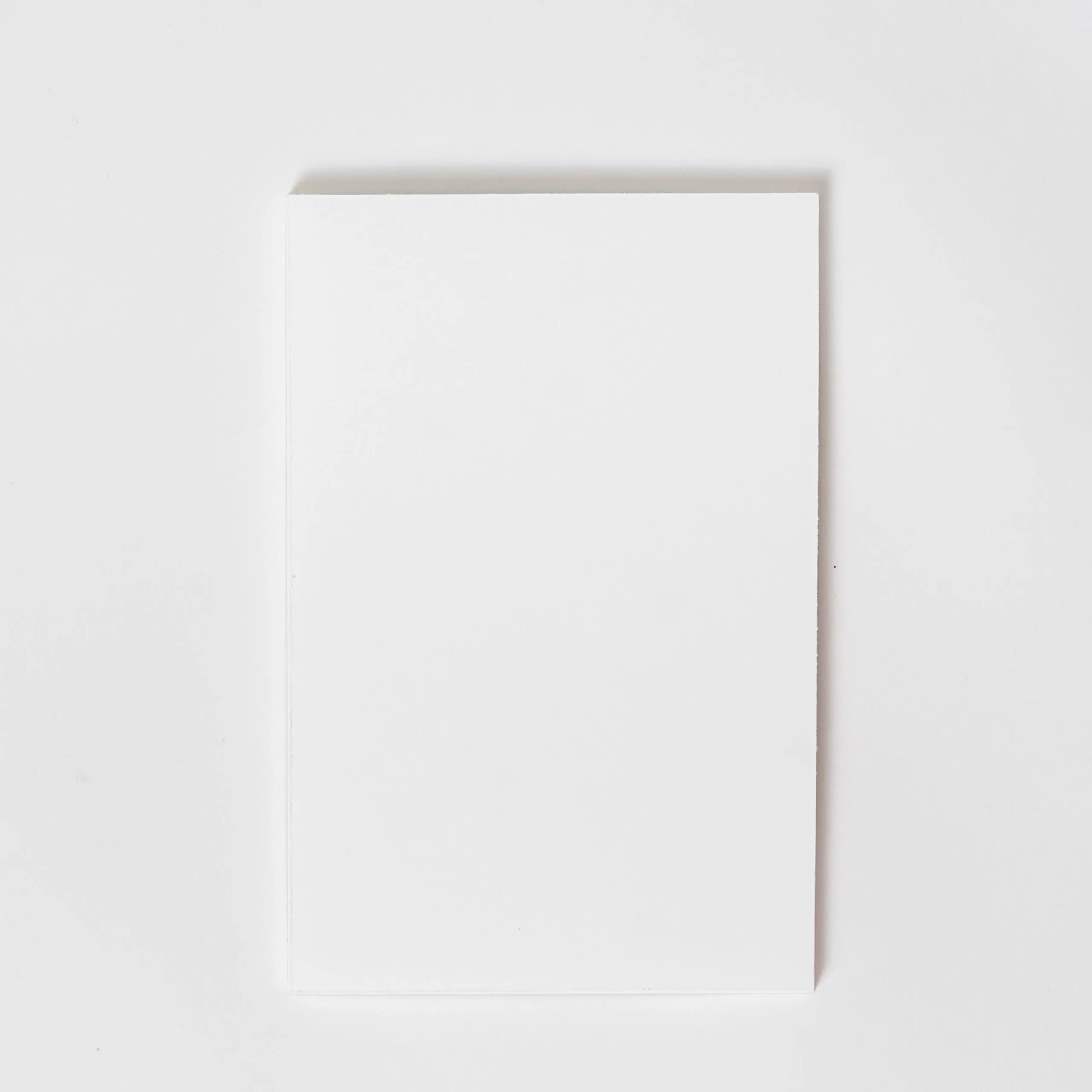 Folha de papel em branco sobre fundo branco - ideal para scrapbooking ou artesanato.