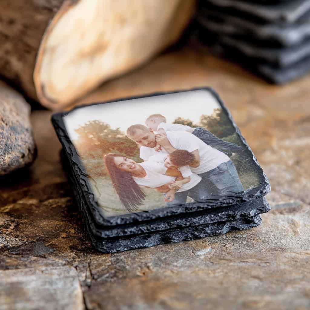 Família feliz com fotos personalizadas em pedra, lembrança especial para ocasiões especiais.
