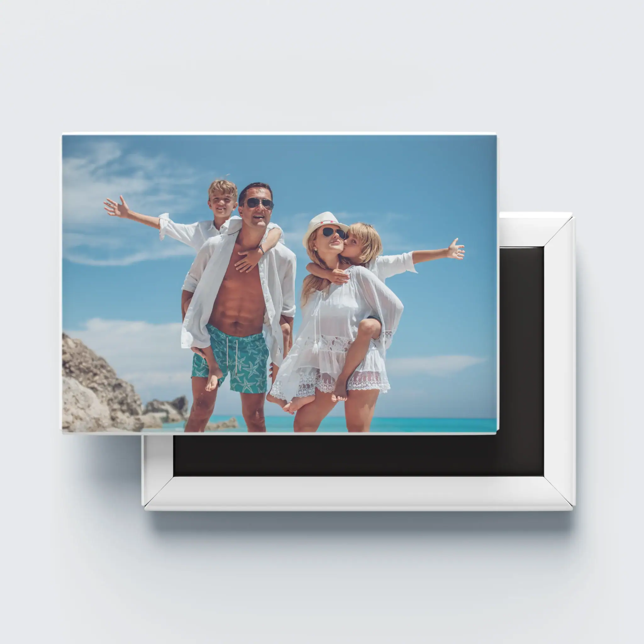 Família sorridente na praia, férias em família, diversão e memórias ao ar livre.