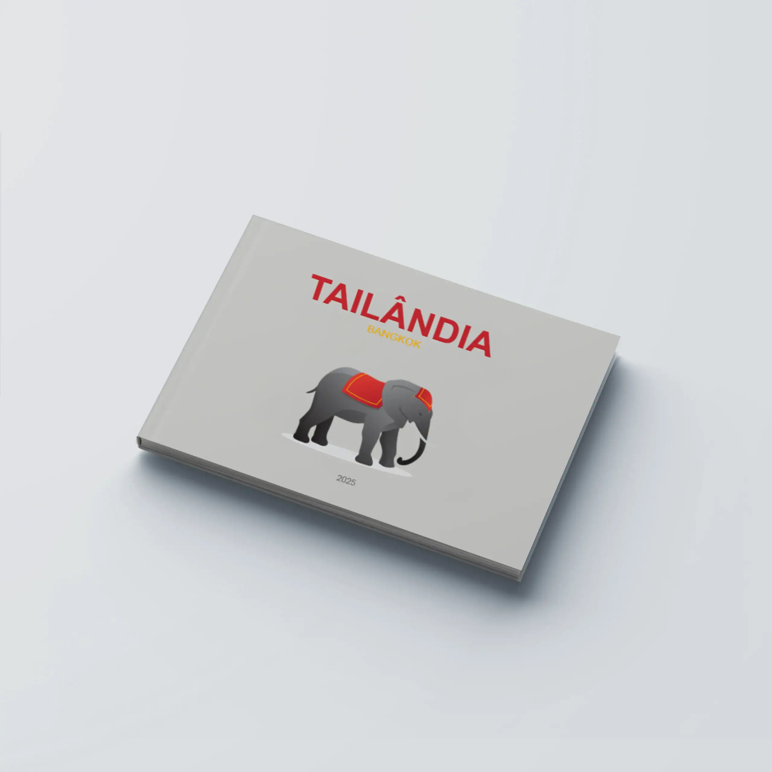Tailândia_CapaDura_H Elefante de peluche com capa de tecido vermelho e detalhes dourados, apresentado na capa do livro "Tailândia" da coleção HappyBooks.